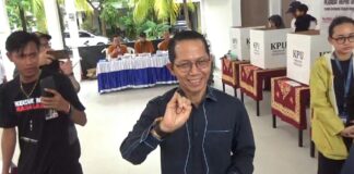 Kenakan Pakaian Serba Biru, Amsakar Mencoblos Ditemani Anak dan Istri amsakar mencoblos ditemani istri